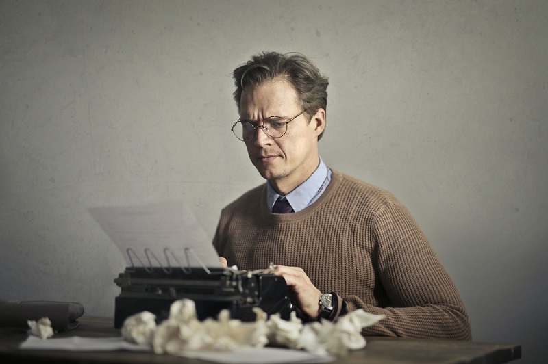 Betriebsblindheit verhindert: Hier im Stimmungsbild, wie ein Mann auf eine alte Schreibmaschine tippt.