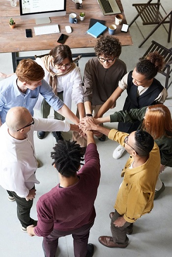 Ein Team stärkt sich zum Teamspirit zusammen im Kreis